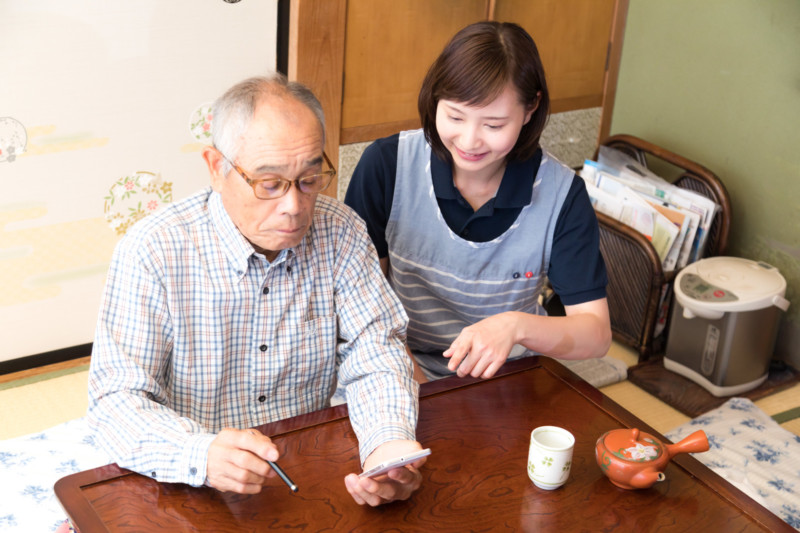 スマホの使い方を若い女性に習うお爺さん